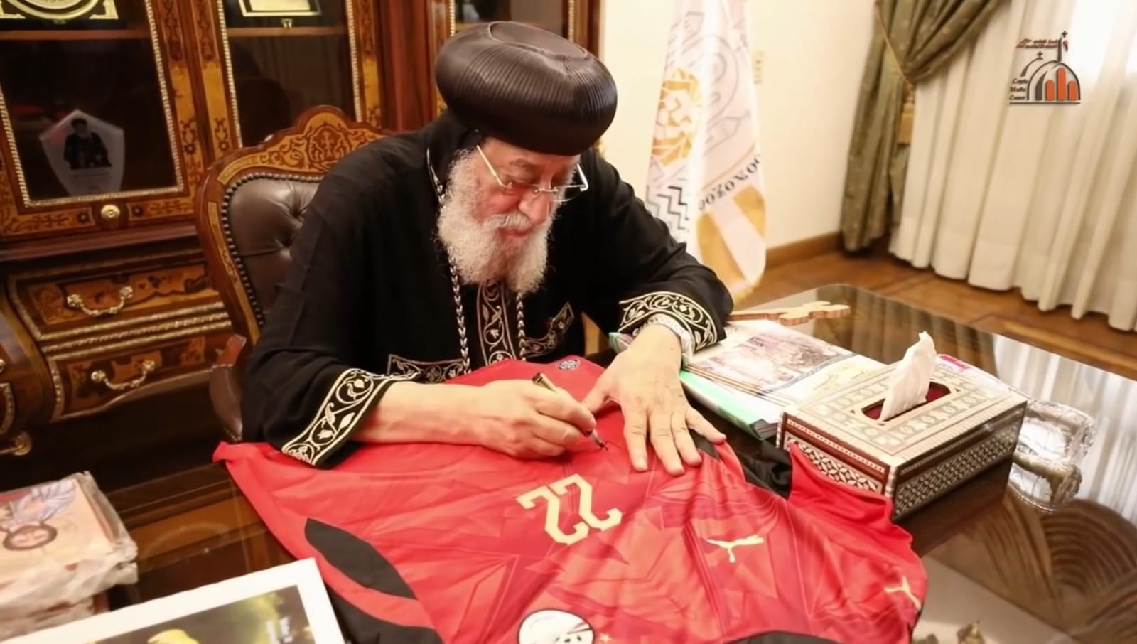 البابا تواضروس يوجه رسالة دعم لمنتخب مصر ويوقع على قميصي محمد صلاح وعمر مرموش